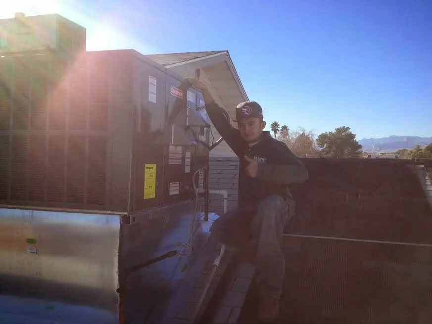 HVAC technician performing AC Tune-Up on a rooftop unit in Milpitas
